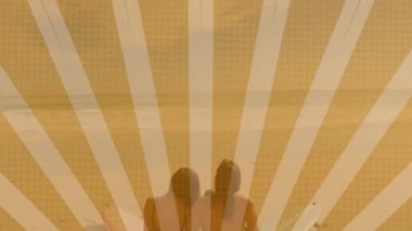 Erkek sörfçü ve kadın sörfçü sahilde oturmuş sörf tahtalarının üstündeki pazarlama verilerini örtüyorlar. Plaj, sörf, deniz kenarı, tatil, rahatlama, macera, sahil