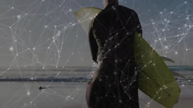 Okyanus sahilinde sörf tahtası tutan dalgıç kıyafeti giymiş bir adam teknoloji ağı kaplaması sergiliyor. Macera, yenilik, bağlantı, açık hava, dinginlik, keşif, modern