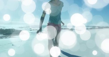 Gezici pazarlama için güneşli sahil boyunca el ele koşan çift animasyon bokeh daireler kullanıyor. Romantizm, macera, eğlence, dinginlik, uyum, arkadaşlık, canlılık