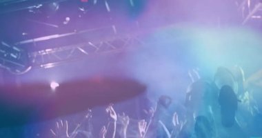 Konser hayranları dalgıç sanatçısına uzanıyor, müzik pazarlamasını dumanlı, renkli ışıklarla gösteriyorlar. Canlı müzik, izleyicilerin ilgisi, canlı ışıklandırma, enerjik atmosfer, sahne performansı, konser kültürü, eğlence sektörü