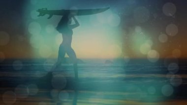 Gün batımında sığ okyanus sularında sörf tahtası taşıyan ve seyahat reklamları için işaret fişeği atan bir kadın. Siluet, sahil, günbatımı, sükunet, macera, açık hava, rahatlık