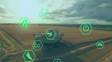 Yeşil eko altıgen simgeleri enerji verilerini gösterirken biçerdöveri keserek altın buğdayı birleştirir. Tarım, sürdürülebilirlik, yenilenebilirlik, makine, kırsal, çevre, yenilik