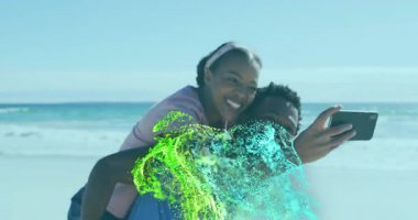 Kadın, plajda akıllı telefondan selfie çeken, içinde dönen teknolojik parçacıklar olan bir adama yaslanıyor. Romantizm, arkadaşlık, gençlik, açık hava, eğlence, canlı, dijital sanat