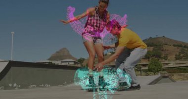 Kaykay rampasında duran çift, teknoloji bağlamında dönen konfeti animasyonlarıyla etkileşime geçiyor. Kentsel, genç, dinamik, canlı, kutlama, boş zaman, açık hava