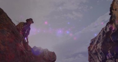 Erkek yürüyüşçü kayalık kanyon boşluğunda yürüyor, animasyon teknoloji haritası simgeleri, sırt çantası ve lens fişeğiyle. Macera, keşif, açık hava, engebeli, manzara, yalnızlık, doğa.