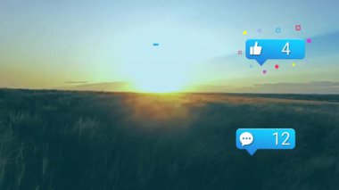 Gün batımında sahada yüzen uyarı baloncukları kalp, kullanıcı gibi yorum simgelerini gösteriyor. Dijital, manzara, canlı, bağlılık, sükunet, kırsal, modern