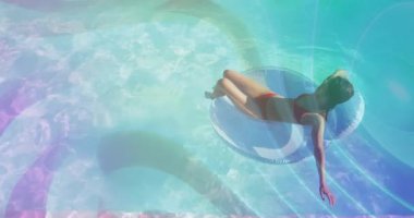 Kırmızı bikinili kadın turkuaz suyla havuz tüpüne yaslanmış, pazarlama için mercek fişekleri sergiliyor. Lüks, rahatlama, rahatlama, hayat dolu, huzur, yaz, açık hava.