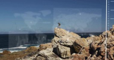 Kayalık sahil şeridinde yürüyüş yapan bir adam yüzen teknoloji HUD grafikleri ve veri şebekeleriyle okyanusu inceliyor. Macera, keşif, engebeli, teknoloji, fütüristik, açık hava, manzara