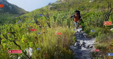 Kıyı yamacında yürüyen erkek yürüyüşçü, pazarlama için yüzen sosyal medya simgeleri gösteriyor. Macera, keşif, doğa, dijital, multimedya, açık hava, engebeli