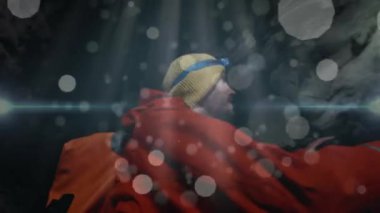 Dağcı mağaranın içindeki farları ayarlıyor, animasyon teknolojili toz parçacıklarını gösteriyor. Macera, keşif, engebeli, açık hava, atmosfer, kararlılık, yalnızlık.