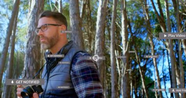 DSLR ile ormanı fotoğraflayan adam teknolojiyi temsil eden yüzen bildirim simgeleri gösteriyor. Doğa, manzara, açık hava, vahşi doğa, teknoloji, sosyal medya, macera