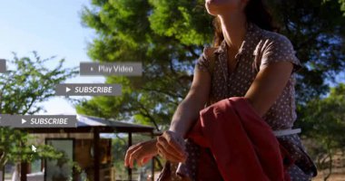 Çadırın altında oturan kırmızı ceketli kadın yüzen sosyal medya bildirimleri sergiliyor. Moda, eğlence, yaşam tarzı, açık hava, doğa, mutluluk, modern