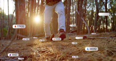 Çam ormanında diz çökmüş, tüfeği kavrayan ve teknolojiyi gösteren uyarı simgeleriyle dolaşan bir adam. Doğa, vahşi doğa, kamuflaj, açık hava, macera, hayatta kalma, teknoloji.