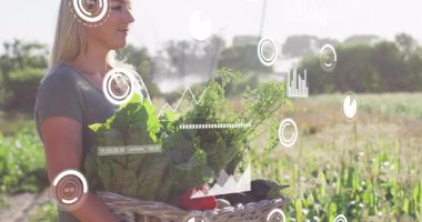 Tarlada sebze sepeti tutan olgun bir kadın çiftçi ve çiftlik haritasında yüzen veri grafikleri var. Tarım, sürdürülebilirlik, teknoloji, çevre dostu, hasat, açık hava, yenilik