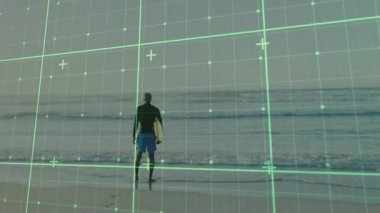 Yetişkin bir adam kumlu sahilde sörf tahtası tutuyor, yeşil ızgarayı örterek teknoloji kavramını gösteriyor. Sahil şeridi, macera, eğlence, coşku, huzur, keşif, açık hava.