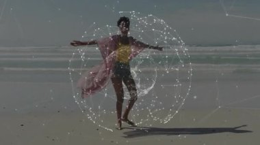 Kadın kumlu sahilde yalınayak yürüyor, beyaz küreler oluşturan teknoloji ağını gösteriyor. Fütürist, dijital, bağlantı, dinginlik, zarafet, minimalizm, yenilik