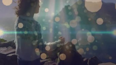 Kayalık kıyı şeridinde duran bir kadın, kamera mercek patlaması ve bokeh efektleri gösteriyor. Macera, keşif, doğa, dinginlik, engebeli, açık hava, çevre