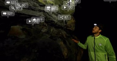 Mağara farlarıyla mağara duvarlarını inceleyen erkek mağara kaşifi teknoloji için yüzen sosyal medya simgeleri gösteriyor. Macera, keşif, engebeli, gece vakti, dijital bağlantı, keşif