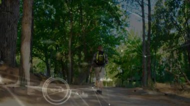 Yetişkin bir erkek yürüyüşçü çam ormanlarında yürüyor ve artırılmış gerçeklik teknolojisi grafiklerini gösteriyor. Macera, keşif, doğa, açık hava, dijital, yenilik, vahşi doğa