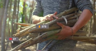 Çam ormanlarında yakacak odun taşıyan bir adam, yüzen sosyal medya ikonlarıyla çatışmayı destekliyor. Doğa, açık hava, kırsal, dijital, sosyal, bağlantı, macera