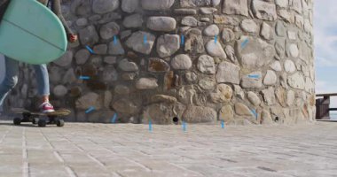 Kaykayda dengede duran bir kadın taş kuledeki sörf tahtasıyla, animasyon sağlık çizelgesi sergiliyor. Macera, boş zaman, açık hava, canlı, dinamik, genç, spor