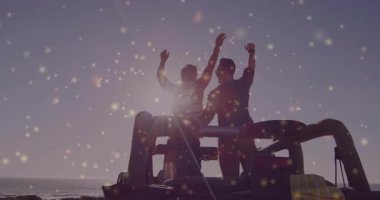 Kayalık sahil şeridinde Jeep 'e yaslanmış iki adam, Bokeh Sparkles ile seyahat tarzı gösteriyor. Macera, dostluk, sahil, seyahat, rahatlama, manzara, açık hava