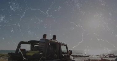 Okyanus kıyısında hareketli seyahat ikonları ve çizelgeleriyle kollarını kaldıran iki adam. Macera, arkadaşlık, açık hava, keşif, boş zaman, özgürlük, canlı