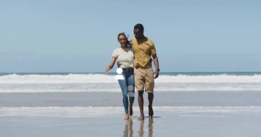 Sahilde bir adamla kol kola yürüyen bir kadın. Animasyon sağlık ikonu ve adım tablosu sergiliyor. Romantizm, birliktelik, rahatlık, sükunet, doğal, bağlantı, canlılık