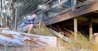 Adam ormanın yanında diz çökmüş bir kulübe tahtası ve animasyon inşaat ikonları onarım gösteriyor. Zanaatkar, açık hava, kırsal, onarım, ahşap işçiliği, doğa, zanaat