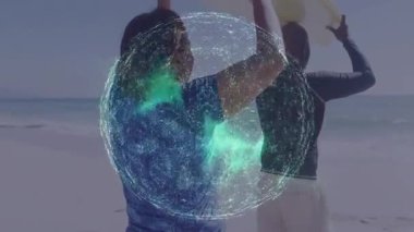 Yeşil ağ resimleme teknolojisini kaplarken kumlu sahilde sörf tahtası taşıyan çift. Macera, eğlence, uyum, bağlantı, açık hava, sağlık, aktif