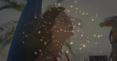 Plajda sörf tahtasına yaslanan bir kadın seyahat pazarlaması için altın parıltılar ve palmiye yaprakları gösteriyor. Plaj, tatil, yaz, eğlence, canlı, açık hava, yaşam tarzı