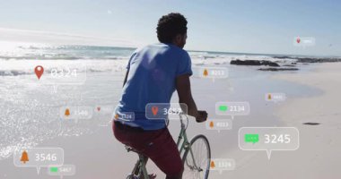 Sahil şeridinde bisiklet süren bisikletçi, yüzen pazarlama mesaj baloncukları ve uyarı simgeleri sergiliyor. Macera, eğlence, canlı, açık hava, teknoloji, iletişim, sahil