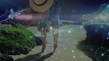 Gelgit havuzunda yürüyen, bacağına dokunan, teknoloji tasarımı için ışıldayan ağ düğümlerini örten bir kadın. Doğa, sahil şeridi, keşif, bağlantı, dinginlik, açık hava, yenilik