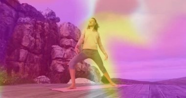 Pembe minderde yoga yapan bir kadın canlandırılmış sağlık simgeleri ve veri tablosu gösteriyor. Zindelik, sağlık, meditasyon, manzara, dinginlik, farkındalık, canlılık
