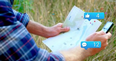 Adam açık hava kağıt haritasını inceliyor, animasyon sosyal medya ikonları dijital pazarlamayı destekliyor. Macera, keşif, seyahat, eğlence, doğa, iletişim, bağlantı