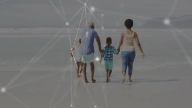 Islak kumda, dalgalara doğru çıplak ayakla yürüyen aile teknoloji ağını gösteriyor. Bağlantı, birlik, arkadaşlık, ahenk, manzara, sükunet, birliktelik
