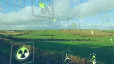 Tarım arazilerini kaplayan yüzen yeşil enerji simgeleri, güç, geri dönüşüm, rüzgar ve CO2 sembolleri. Sürdürülebilirlik, yenilenebilirlik, çevre dostu, dijital görseller, çevresel bilinç, doğa, kırsal