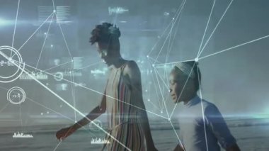 Anne ve kızı kumlu sahilde yürüyor, teknolojik verileri gözler önüne seriyorlar. Aile, sahil, yaz, açık hava, bağlantı, dinginlik, coşku