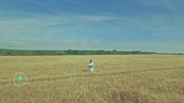 Buğday tarlasında dizüstü bilgisayarda çalışan Agronomist araştırmacı, yüzen enerji simgeleri gösteriyor. Bilim adamı, teknoloji, sürdürülebilirlik, yenilik, kırsal, tarım arazisi, modern