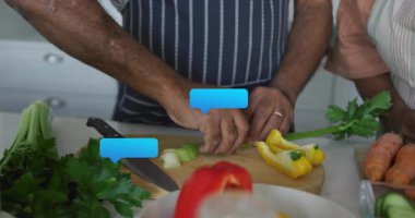 Son sınıf çifti tezgahta sebze doğruyor, yüzen sohbet baloncuklarını gösteriyor yemek pişirme teknolojilerini sergiliyorlar. Sağlıklı yemek, yerli, yaşam tarzı, canlı, besleyici, aşçı, çevre