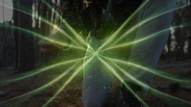 Olgun erkek okçu ormanda açık yay çizerek neon-yeşil teknoloji izlerini örtüyor. Okçuluk, avcılık, yaban hayat, macera, teknoloji, doğa, odaklanma