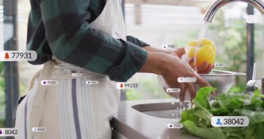 Ev aşçısı mutfakta sarı dolmalık biber yıkıyor, yemek pişirme derslerini sosyal ikonlarla sunuyor. Aşçılık, aşçılık, mutfak, sağlıklı, yaşam tarzı, modern, canlı