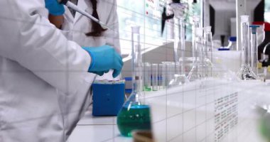 Mataranın yanında pipeti tutan kadın laboratuvar teknisyeni bilim grafikleri ve renkli görselleri örtüyor. Araştırma, mikroskop, yenilik, kimya, deney, hassasiyet, teknoloji