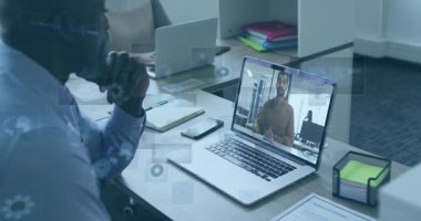 İş yerindeki masasında oturan profesyonel bir erkek, grafikle örtüşen sanal toplantıyı izliyor. Teknoloji, takım çalışması, iletişim, üretkenlik, modern, kurumsal, dijital