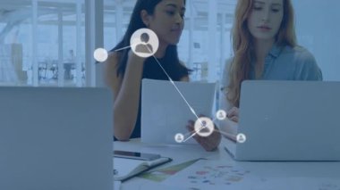 İş ortaklığı için ağ simgelerini gösteren belgeyi inceleyen iki iş arkadaşı. İşbirliği, takım çalışması, iletişim, modern, profesyonel, dijital, yenilik