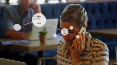 Kadın ve iş arkadaşı, yüzen akıllı telefon müzik sohbet simgeleriyle iş kafesinde çalışıyor. İşbirliği, bağlantı, modern, çalışma alanı, dijital, iletişim, teknoloji