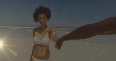 Kumsalda partnerini tutan kadın animasyon pazarlama grafiği ve güneş ikonu kaplamalarını gösteriyor. Tatil, boş zaman, kaygısız, canlı, açık hava, doğa, mutluluk