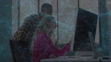 Modern teknoloji ofis masasında iş birliği yapan meslektaşlar bilgisayar üzerinden mavi dijital ağı keşfediyorlar. Çalışma alanı, profesyoneller, teknoloji, iletişim, yenilik, işbirliği, modernite