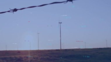 Otlakta dönen rüzgar türbini, dijital HUD örtüsünü 3 boyutlu olarak gösteriyor. Yenilenebilir enerji, sürdürülebilirlik, teknoloji, gelecek, çevre dostu, yenilik, geniş arazi