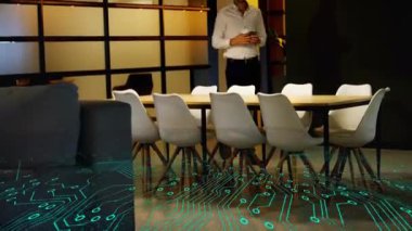 Ofiste elinde kahve fincanı ve akıllı telefon tutan bir adam iş teknolojisi devre kartı kaplamasını sergiliyor. Profesyonel, kurumsal, modern, minimalist, teknoloji, işbirliği, ağ